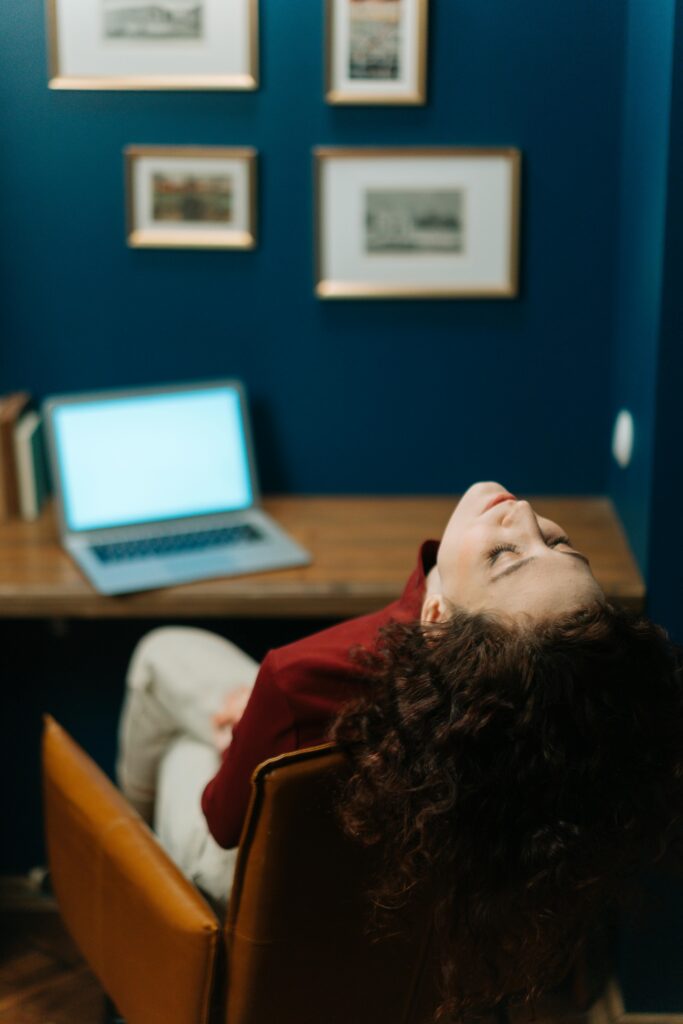micro-sieste en entreprise, femme fermant les yeux devant son bureau pour récupérer