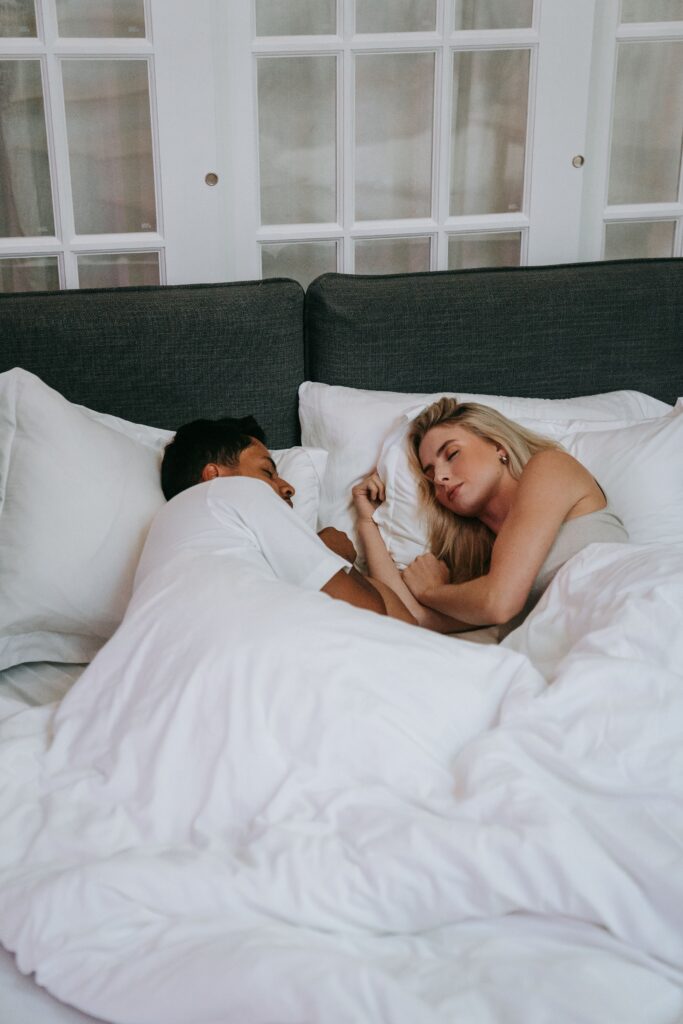 A relaxed couple sleeping together in a cozy bedroom, expressing love and tranquility.